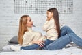 Mother and her daughter child girl playing and hugging on bed Royalty Free Stock Photo