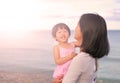 Happy loving family. Mother and her daughter child girl playing and hugging on sea background in the evening Royalty Free Stock Photo