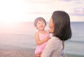 Happy loving family. Mother and her daughter child girl playing and hugging on sea background in the evening Royalty Free Stock Photo