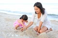 Happy loving family. Mother and her daughter child girl playing sand at the beach Royalty Free Stock Photo