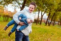 Happy loving family in the park. Mother in white and baby boy in blue having fun, playing and laughing in nature Royalty Free Stock Photo