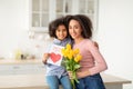 Black daughter greeting mom with tulips and card Royalty Free Stock Photo