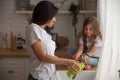 Happy loving family preparing food together. Smiling Mom and child daughter girl washing fruits and vegetables and Royalty Free Stock Photo