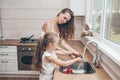 Happy loving family preparing food together. Smiling Mom and child daughter girl washing fruits and vegetables and having fun in Royalty Free Stock Photo