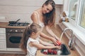 Happy loving family preparing food together. Smiling Mom and child daughter girl washing fruits and vegetables and having fun in Royalty Free Stock Photo