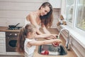 Happy loving family preparing food together. Smiling Mom and child daughter girl washing fruits and vegetables and having fun in Royalty Free Stock Photo