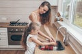 Happy loving family preparing food together. Smiling Mom and child daughter girl washing fruits and vegetables and having fun in Royalty Free Stock Photo