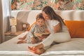Pretty young mother reading a book to her little son in modern interior Royalty Free Stock Photo