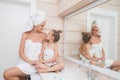 Happy loving family spending time together. Mother and her daughter child girl kissing and hugging in white bathroom. Woman and Royalty Free Stock Photo