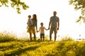 Happy loving family walking outdoor in the light of sunset. Father, mother, son and daughter. Royalty Free Stock Photo