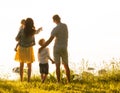 Happy loving family walking outdoor in the light of sunset. Father, mother, son and daughter. Royalty Free Stock Photo