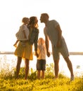 Happy loving family walking outdoor in the light of sunset. Father, mother, son and daughter. Royalty Free Stock Photo