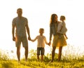 Happy loving family walking outdoor in the light of sunset. Father, mother, son and daughter. Royalty Free Stock Photo
