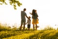 Happy loving family walking outdoor in the light of sunset. Father, mother, son and daughter. Royalty Free Stock Photo