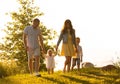 Happy loving family walking outdoor in the light of sunset. Father, mother, son and daughter. Royalty Free Stock Photo