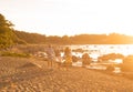 Happy loving family walking outdoor in the light of sunset. Father, mother, son and daughter. Sea and field background Royalty Free Stock Photo