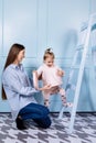 Happy loving family. young Mother in blue and her little daughter in pink clothes playing with pink gift box and blue ladder on Royalty Free Stock Photo