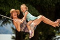 Happy loving family! Young mother and her child daughter swinging on the swings and laughing a summer evening outdoors, beautiful Royalty Free Stock Photo