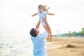 Happy loving father throws up little 3 year old daughter by the sea. People can fly Royalty Free Stock Photo
