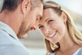 Happy and loving mature caucasian couple enjoying a romantic date at the beach together on a sunny day. Cheerful Royalty Free Stock Photo