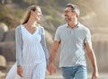 Happy and loving mature caucasian couple enjoying a romantic walk at the beach together on a sunny day. Cheerful Royalty Free Stock Photo