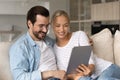 Happy loving millennial family couple using digital tablet. Royalty Free Stock Photo