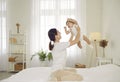 Happy, loving mother and her cute baby playing and having fun on the bed at home Royalty Free Stock Photo