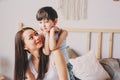 Happy loving mother hugs with child son in the morning in bed