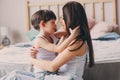 Mother playing with child son in bedroom. Happy family wearing pajamas Royalty Free Stock Photo