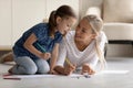 Happy loving mother and little daughter drawing, lying on floor Royalty Free Stock Photo