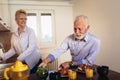 Loving senior couple having fun preparing healthy food on breakfast in the kitchen Royalty Free Stock Photo