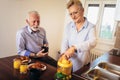 Loving senior couple having fun preparing healthy food on breakfast in the kitchen Royalty Free Stock Photo