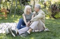 Happy loving senior couple having picnic in garden, embracing and smiling to each other, sitting together outdoors Royalty Free Stock Photo