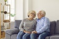 Happy loving senior couple hugging and looking at each other while sitting on sofa at home. Royalty Free Stock Photo