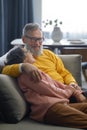 Happy loving senior couple hugging on sofa at home Royalty Free Stock Photo