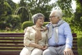 Happy loving senior couple sitting on bench and hugging looking into eyes Royalty Free Stock Photo