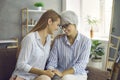 Happy loving senior mother and grown up daughter sitting on sofa, holding hands and smiling Royalty Free Stock Photo