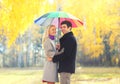 Happy loving smiling couple with colorful umbrella in sunny park