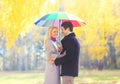 Happy loving smiling couple with colorful umbrella in warm sunny