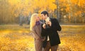 Happy loving young couple taking picture with film camera in autumn park on warm sunny day Royalty Free Stock Photo