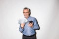 Happy lucky businessman holding smartphone and dollars