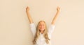 Happy lucky caucasian middle-aged woman employee manager in white office shirt having fun or feels victory stretching or raising