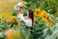 Happy mother with the daughter in the field with sunflowers. mom and baby girl having fun outdoors. family concept Royalty Free Stock Photo