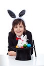 Happy magician boy smile after successfully pulling a grumpy easter bunny from the hat Royalty Free Stock Photo