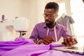 Happy male african designer constructor engineer writing down ideas in a notebook in studio