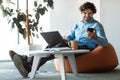 Portrait of smiling man using smartphone and pc at office