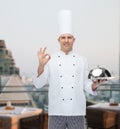 Happy male chef cook with cloche showing ok sign