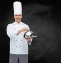 Happy male chef cook holding cloche