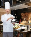 Happy male chef cook holding cloche