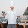 Happy male chef cook opening cloche